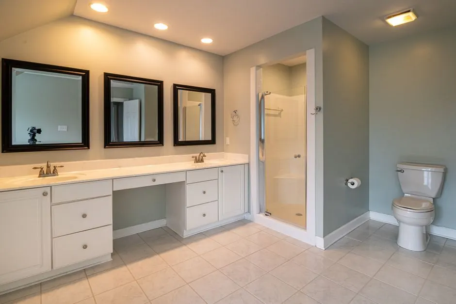 Large bathroom with a double vanity, framed mirrors and a shower cubicle